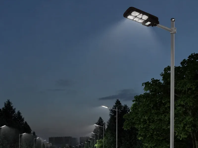 All-in-one solar street lights along a rural road at dusk, each fixture combining the solar panel, battery and LED in one pole-mounted body